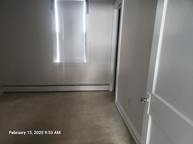 unfurnished room with a baseboard heating unit and carpet floors