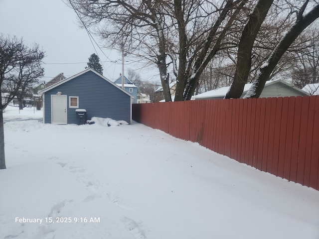 snowy yard featuring fence