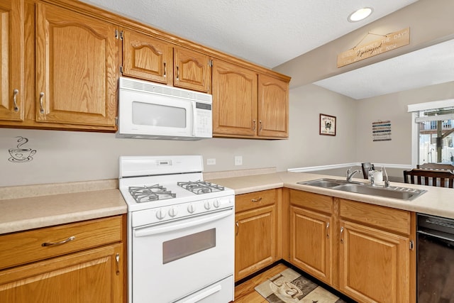 kitchen featuring a textured ceiling, white appliances, a sink, light countertops, and brown cabinets