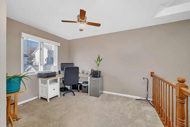 office featuring baseboards, ceiling fan, and light colored carpet