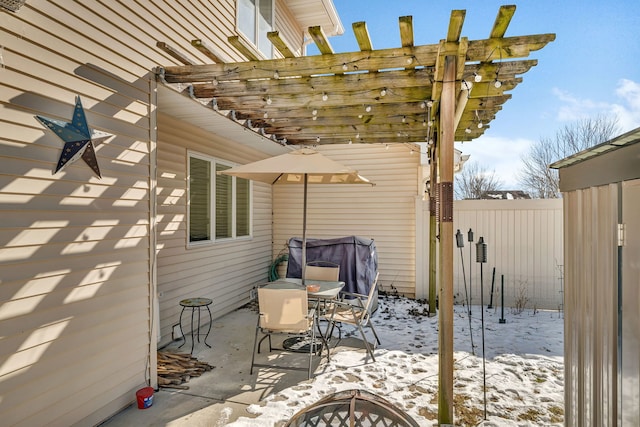 snow covered patio with outdoor dining space, fence, an outdoor fire pit, and a pergola