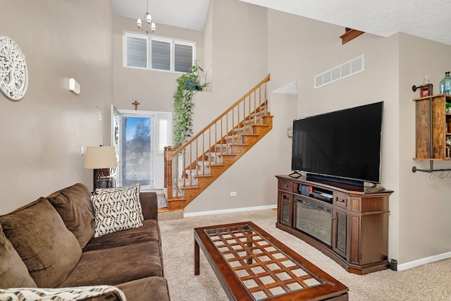 carpeted living room featuring a towering ceiling, baseboards, stairs, and visible vents