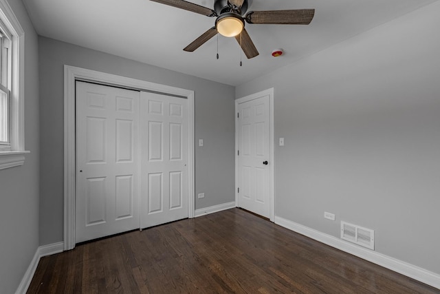 unfurnished room featuring a ceiling fan, baseboards, visible vents, and dark wood-type flooring