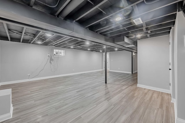finished basement featuring baseboards, stairs, and wood finished floors