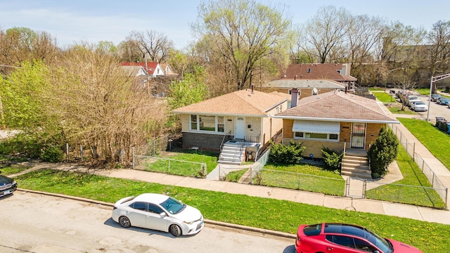 view of front facade featuring fence private yard, a front lawn, and brick siding