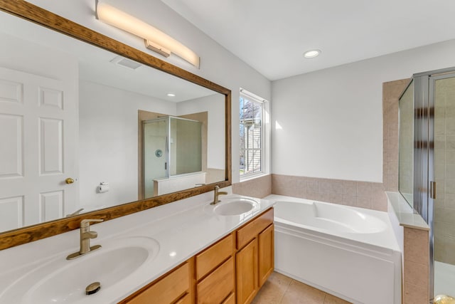full bathroom with a bath, a stall shower, a sink, and tile patterned flooring