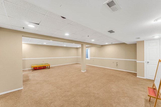 basement with a drop ceiling, baseboards, carpet, and visible vents
