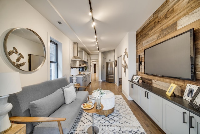 living area with wooden walls and dark wood finished floors