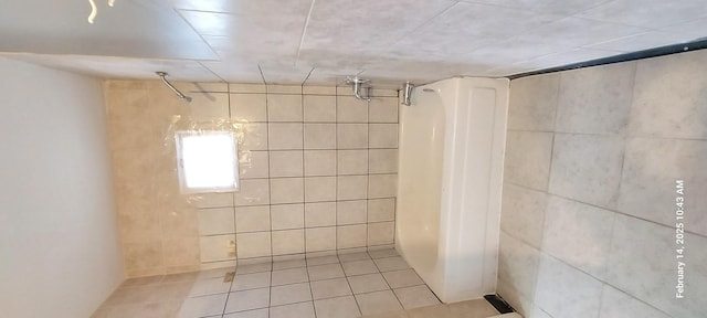 bathroom featuring tile patterned flooring, walk in shower, and tile walls