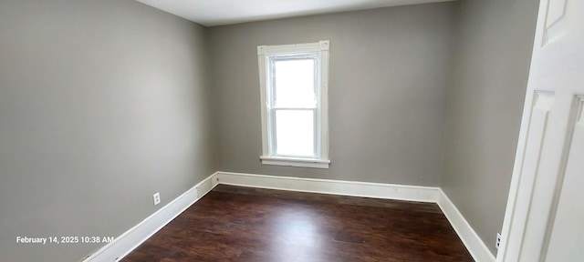 empty room with baseboards and dark wood-type flooring