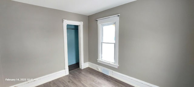 unfurnished bedroom featuring light wood-style floors, multiple windows, baseboards, and a closet