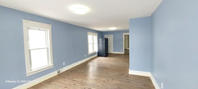 spare room with light wood-type flooring and baseboards