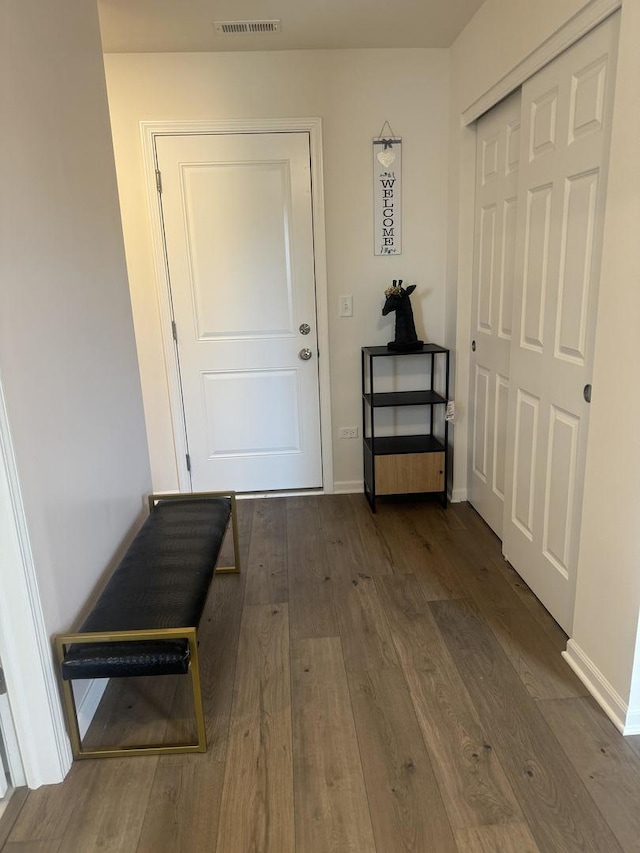 doorway to outside featuring dark wood-style floors, baseboards, and visible vents