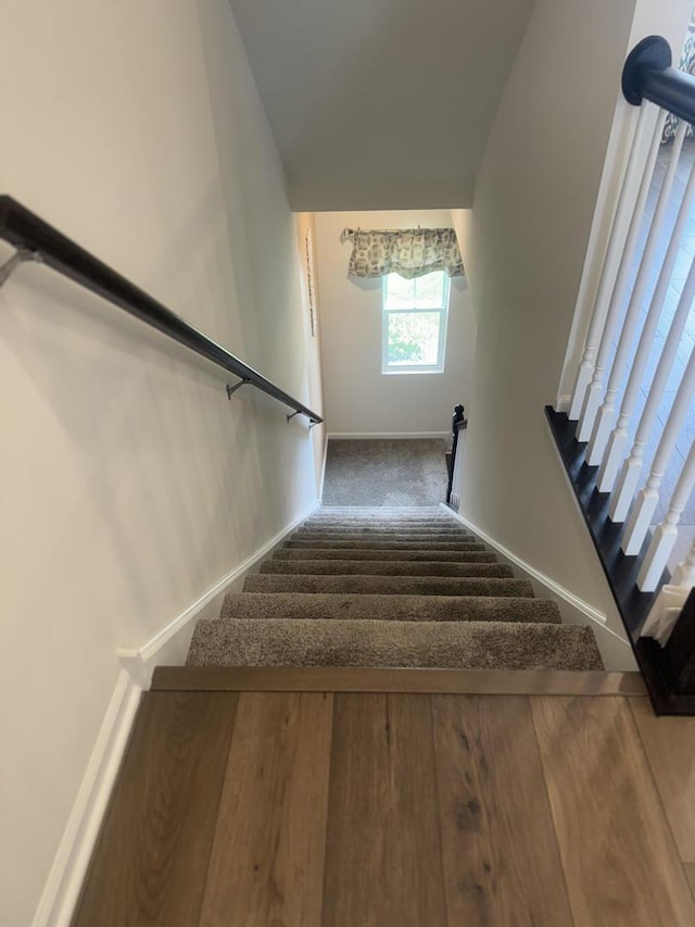 staircase featuring carpet and baseboards