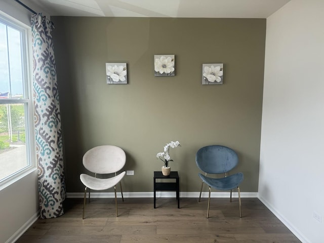 living area with baseboards and wood finished floors