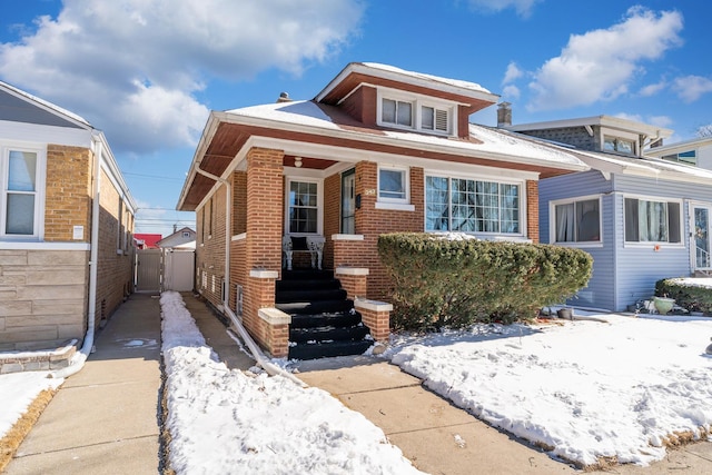 bungalow-style home with driveway and brick siding