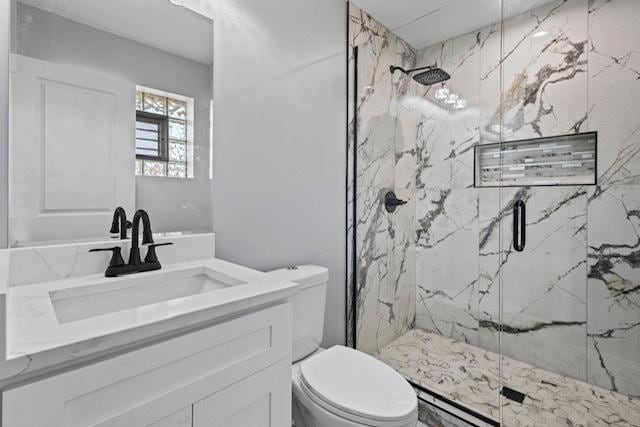 full bathroom with vanity, a marble finish shower, and toilet