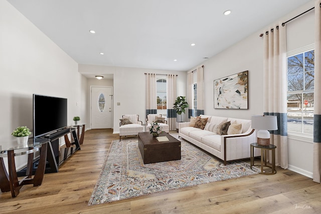 living room featuring recessed lighting, baseboards, and light wood finished floors