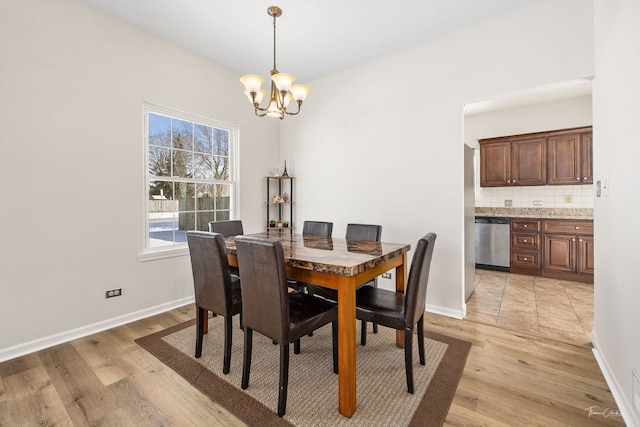 dining space featuring light wood-style flooring, baseboards, and an inviting chandelier