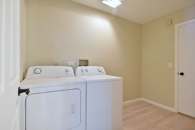 laundry area featuring laundry area, light wood-style flooring, baseboards, and washer and dryer