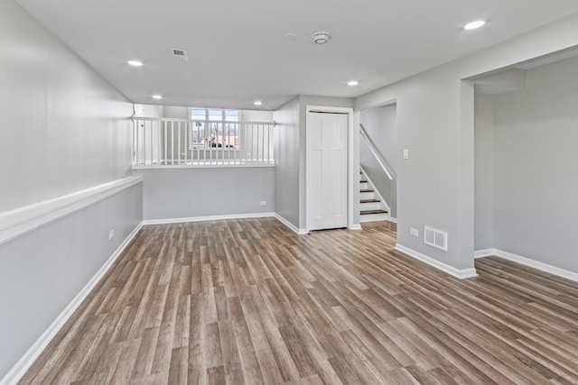 basement with wood finished floors, visible vents, and baseboards