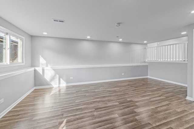 empty room with baseboards, visible vents, wood finished floors, and recessed lighting