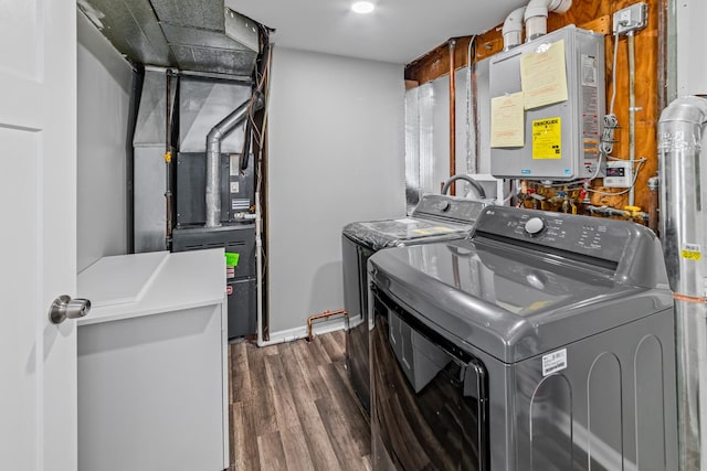 laundry room with laundry area, dark wood-style floors, independent washer and dryer, heating unit, and water heater