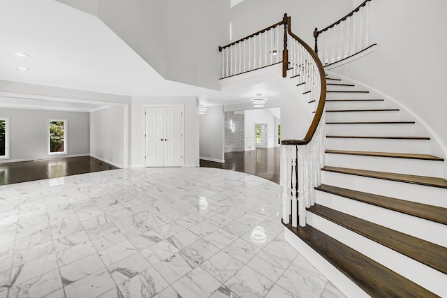 entryway featuring stairs, marble finish floor, a high ceiling, and recessed lighting