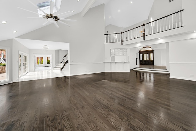 unfurnished living room with ceiling fan, baseboards, dark wood finished floors, and french doors