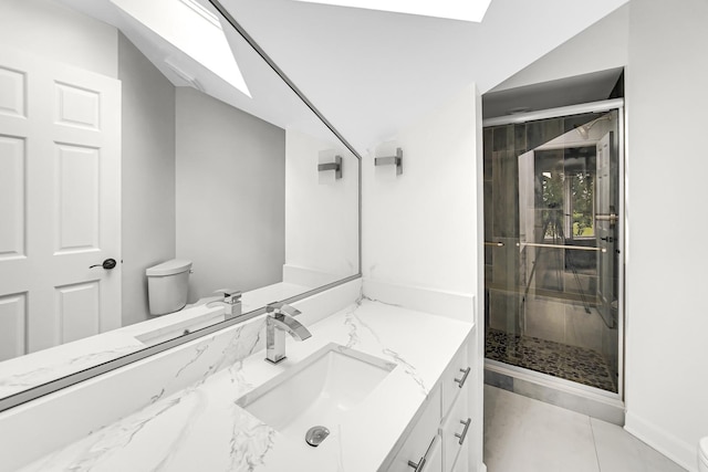 bathroom with toilet, lofted ceiling with skylight, a shower stall, and vanity