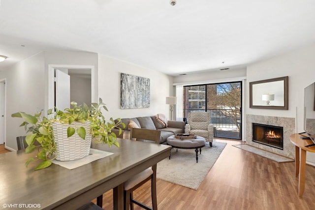 living room featuring a premium fireplace and light wood-style flooring