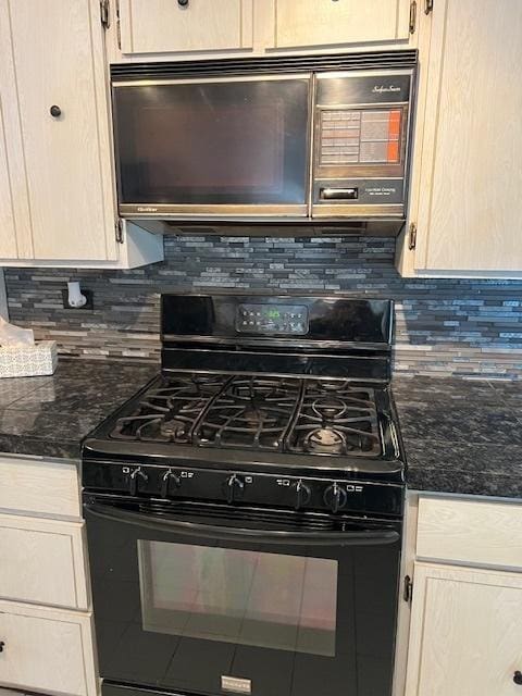 kitchen with black appliances, dark stone counters, decorative backsplash, and light brown cabinetry