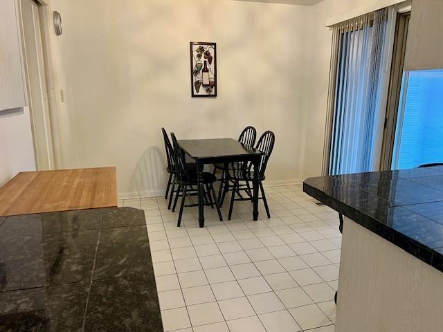 dining space featuring light tile patterned floors and baseboards