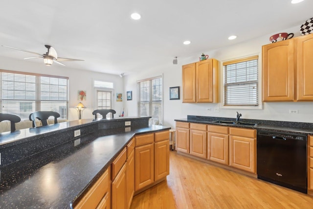 kitchen with black dishwasher, light wood-type flooring, a sink, and recessed lighting