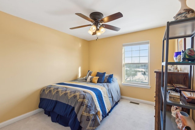 bedroom featuring baseboards, ceiling fan, visible vents, and light colored carpet