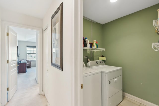 clothes washing area with laundry area, baseboards, and washer and dryer