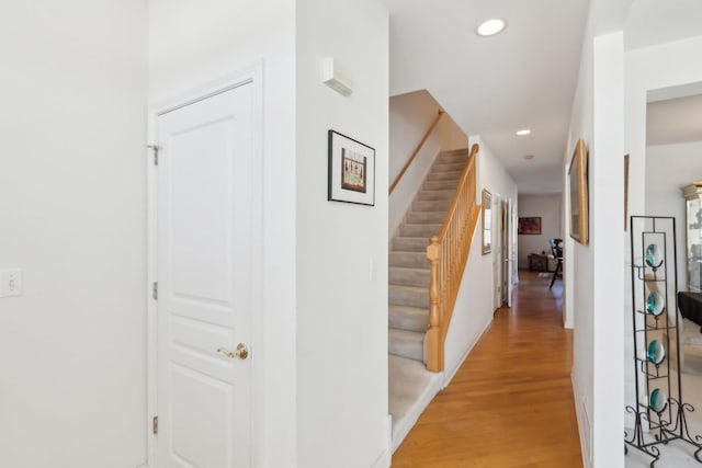 hall with stairs, wood finished floors, and recessed lighting