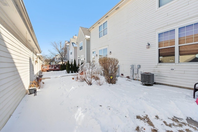 yard layered in snow featuring central air condition unit