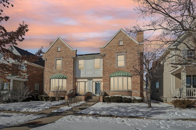 view of front of property featuring brick siding and a chimney