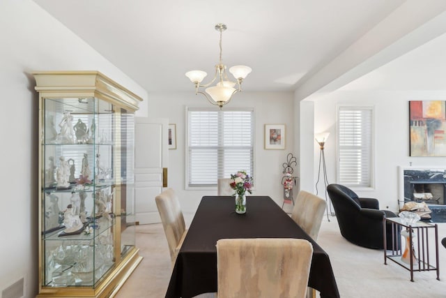 dining room featuring a high end fireplace, visible vents, and light colored carpet