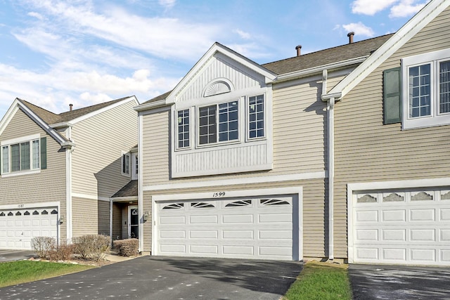 view of front of home featuring a garage, aphalt driveway, and board and batten siding