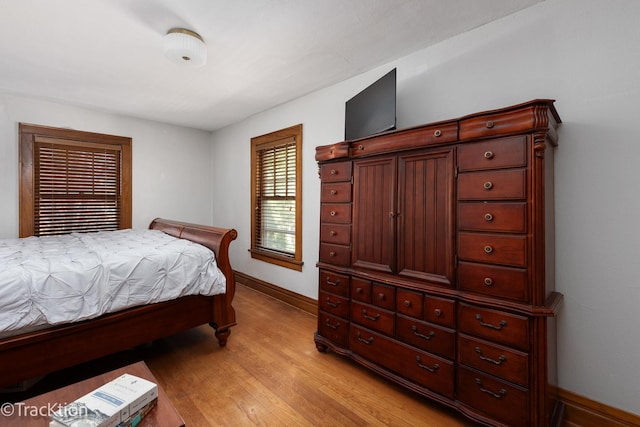 bedroom with baseboards and light wood finished floors