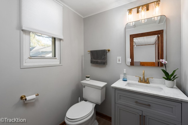 bathroom featuring toilet, ornamental molding, and vanity