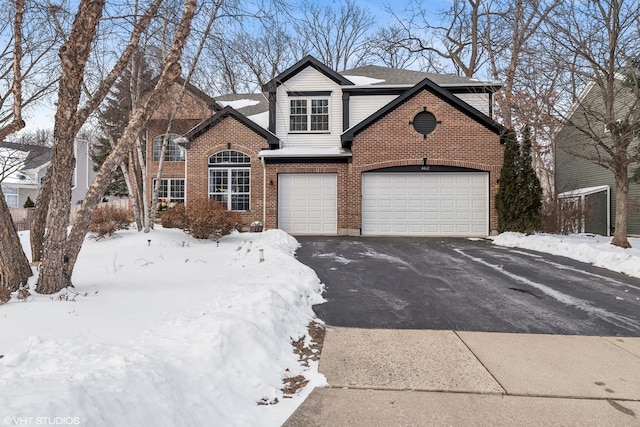 traditional-style house with aphalt driveway, brick siding, a garage, and roof with shingles