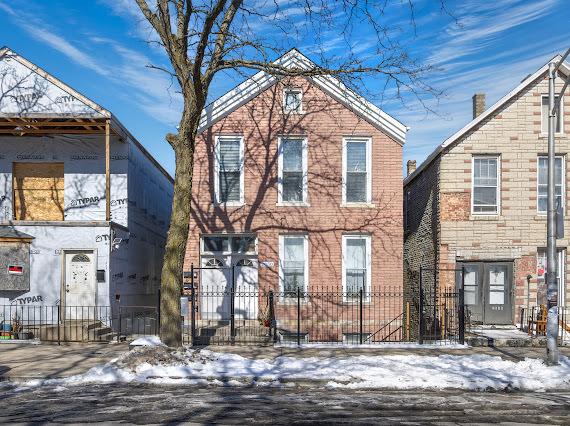 view of front of property featuring a fenced front yard and brick siding