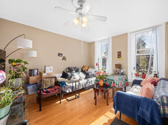 living room featuring light wood-type flooring, a wealth of natural light, and a ceiling fan