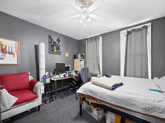 bedroom featuring dark colored carpet and ceiling fan