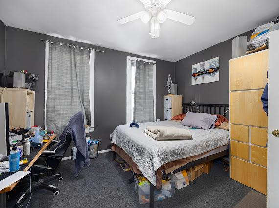 bedroom featuring dark colored carpet and a ceiling fan