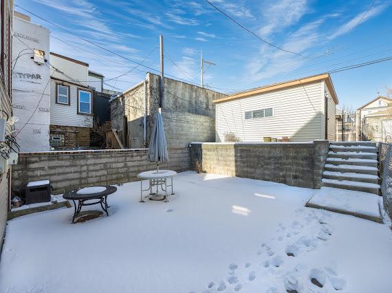 snow covered back of property with fence and central AC unit