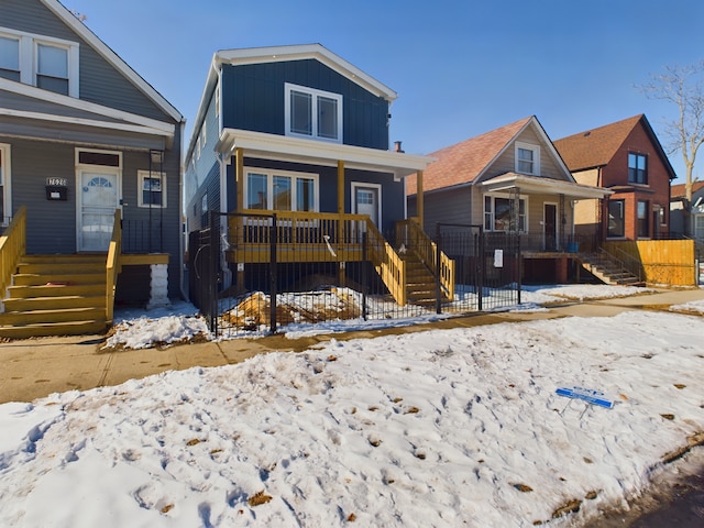 view of front of property with covered porch, stairway, and board and batten siding